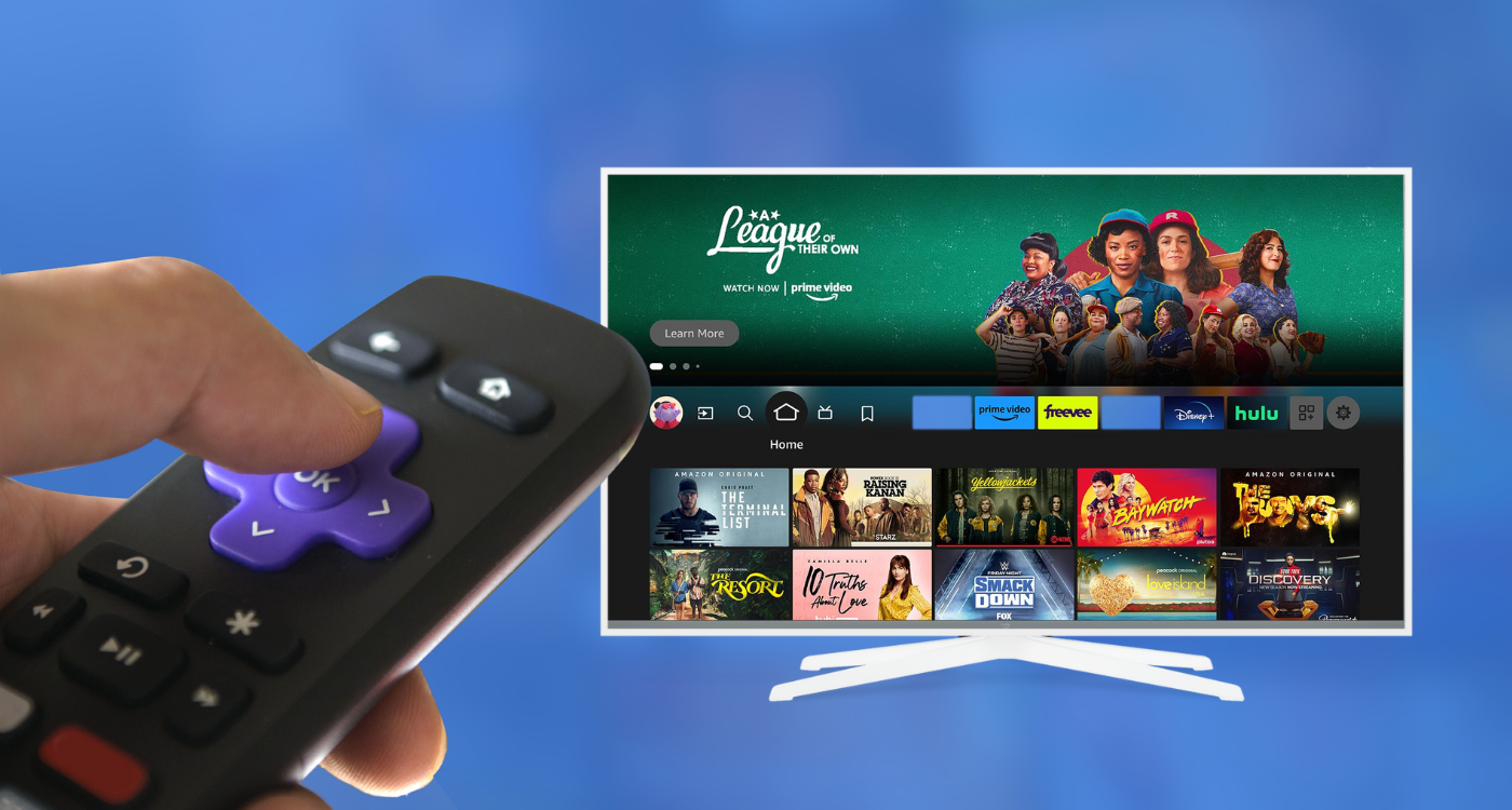 Hand holding a streaming remote pointed at a smart TV displaying various streaming apps and Amazon Prime Video content.