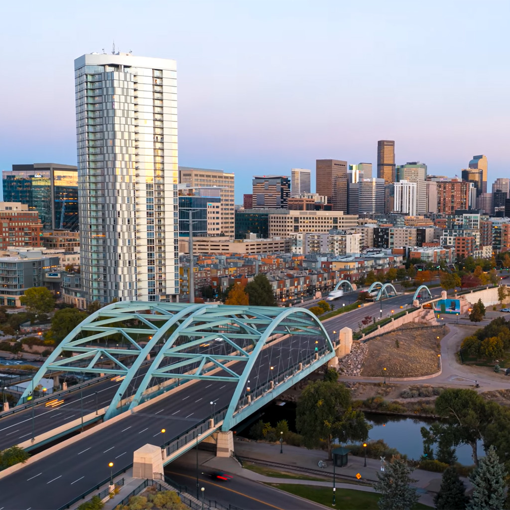 Aerial view of the Denver skyline and arched bridge at dusk